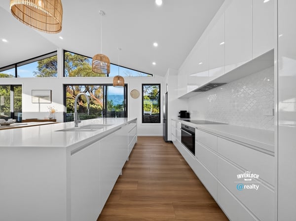Modern kitchen featuring sleek cabinetry, ample natural light, and scenic views, perfect for culinary enthusiasts.