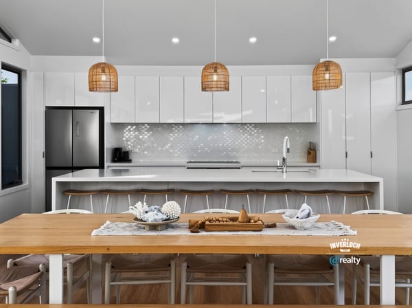 Modern open-plan kitchen featuring sleek cabinetry, a spacious dining area, and unique pendant lighting.