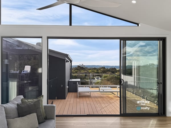 Bright and airy living space opens to a spacious deck, offering stunning views of the landscape.