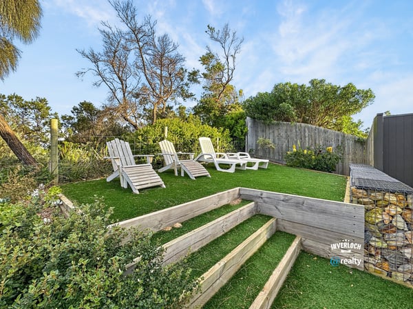 Discover a peaceful outdoor retreat featuring landscaped steps and ample seating for relaxation and enjoyment.