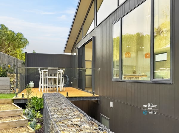Modern home featuring an expansive deck, perfect for outdoor dining and enjoying scenic views.