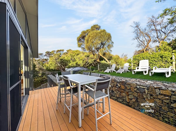 Modern outdoor patio seamlessly blends with nature, featuring ample seating and vibrant landscaping. Perfect for gatherings!