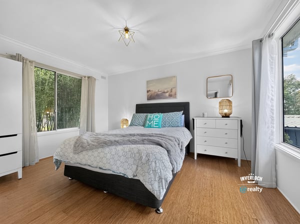 Spacious bedroom featuring abundant natural light, modern decor, and a cozy atmosphere for relaxation.