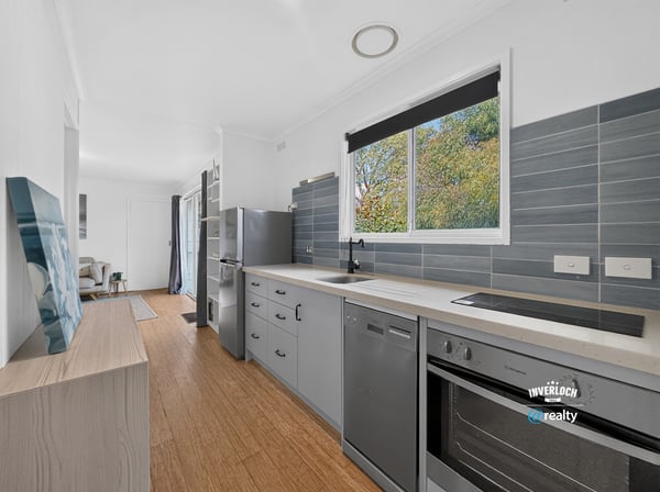 Discover a modern kitchen featuring sleek cabinetry, updated appliances, and abundant natural light throughout the space.