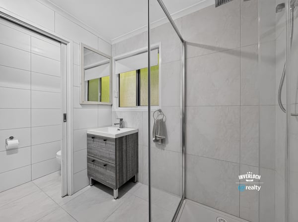 Modern bathroom featuring dual mirrors, a spacious shower, and sleek cabinetry for efficient storage.