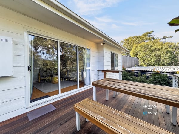 Bright outdoor space featuring a spacious deck, perfect for gatherings and enjoying the surrounding greenery.