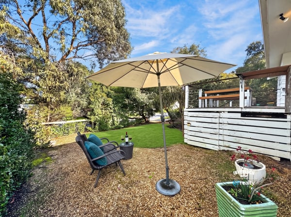 Inviting outdoor space features a shaded seating area, perfect for relaxation or entertaining amid lush greenery.
