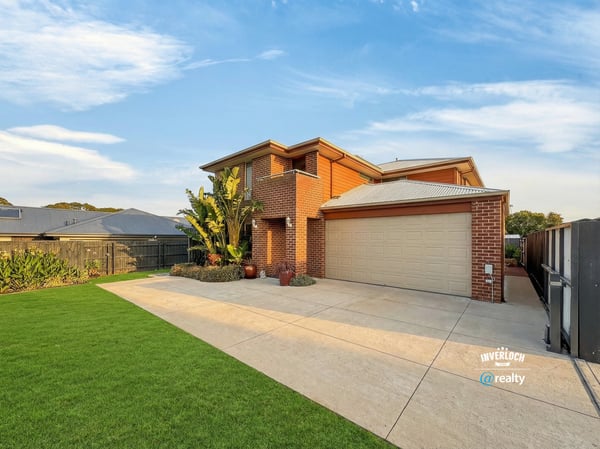 Spacious two-story home with a well-maintained lawn, perfect for family living and outdoor activities.