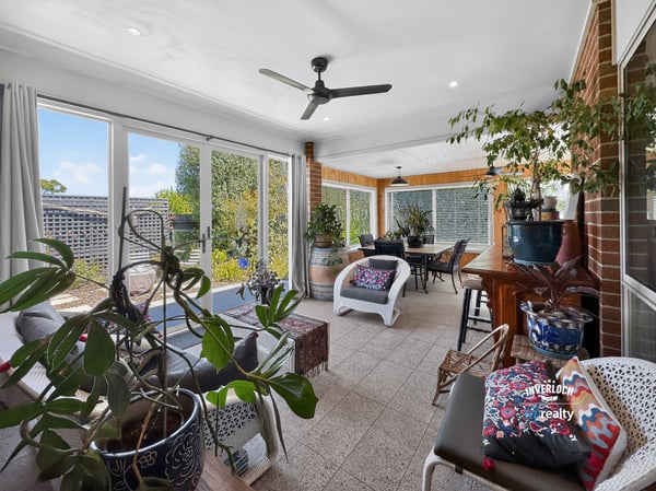 Bright and inviting sunroom with abundant greenery, perfect for relaxation and entertaining year-round.