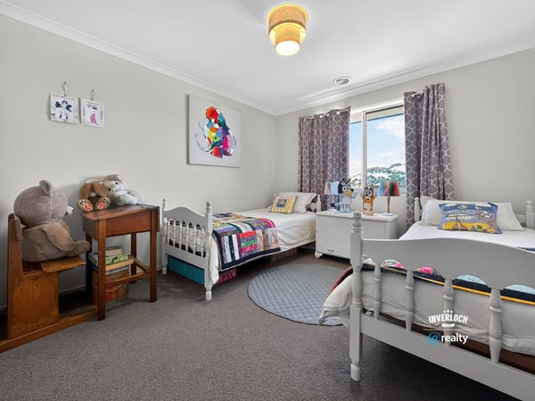 Bright and inviting bedroom featuring cozy beds, playful decor, and ample natural light. Perfect for creativity!
