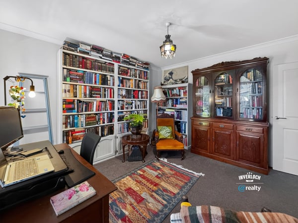 Cozy reading nook with expansive bookshelves and a versatile workspace, perfect for relaxation and productivity.