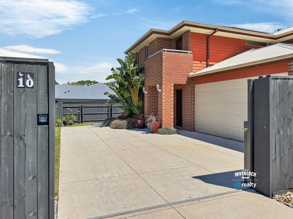 Modern home with a spacious driveway, vibrant landscaping, and convenient access to outdoor amenities.