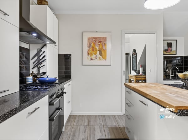 Modern kitchen featuring sleek appliances, ample counter space, and distinct artwork for a vibrant touch.