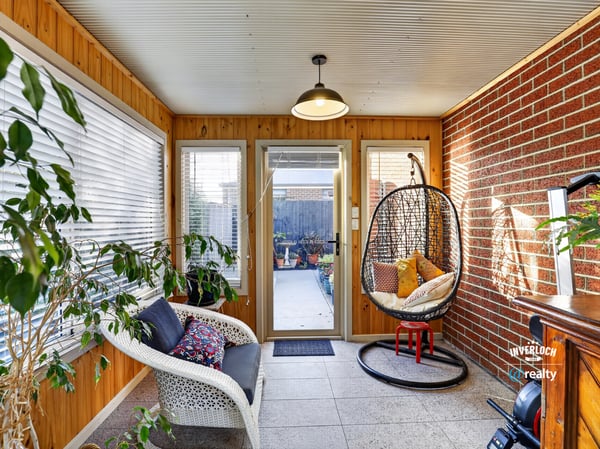 Bright sunroom featuring a cozy seating area and access to a beautifully landscaped outdoor space.