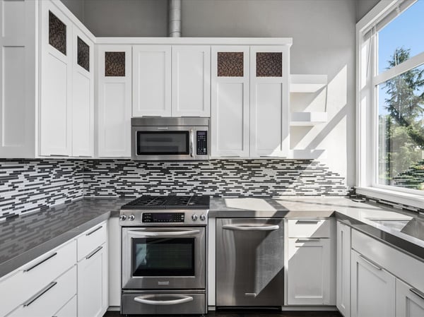 White cabinets, dishwasher, hardwood floors.