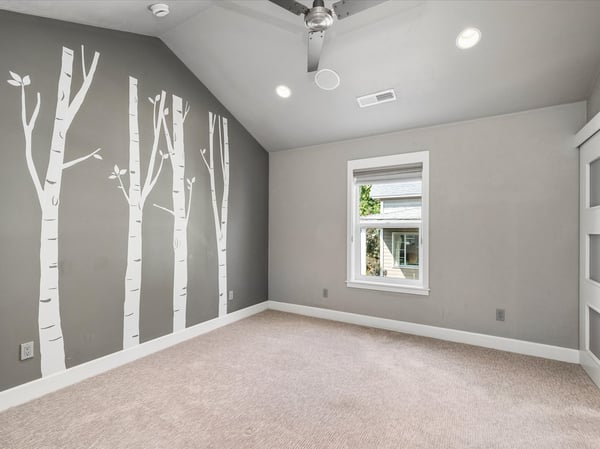 Primary suite with a vaulted ceiling, ceiling fan, walk-in closet and private bathroom.