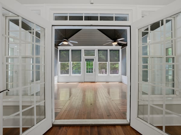 Sunroom featuring large windows and hardwood floors, perfect for entertaining or relaxing.