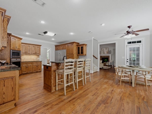 Spacious open-concept kitchen features warm beautiful cabinetry, a large island, and seamless flow to the dining area. Some cabinets have pull out shelves, which makes staying organized easy.