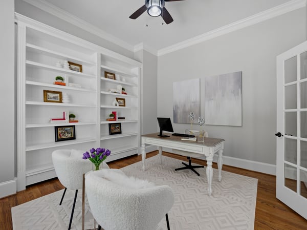Bright and airy office space featuring built-in shelves.