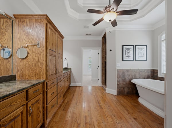 Primary bathroom featuring rich wood cabinetry, modern fixtures, and a freestanding tub for relaxation.