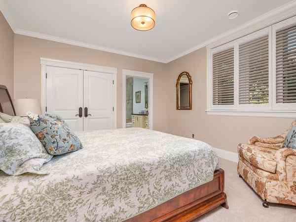 An inviting fourth bedroom featuring ample natural light and an en-suite bathroom for convenience.