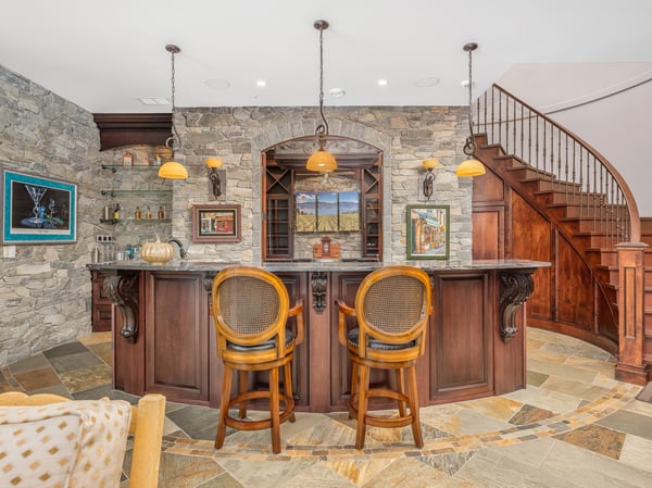 Discover a unique bar area featuring stone accents, custom cabinetry, and inviting seating, perfect for wine tasting.