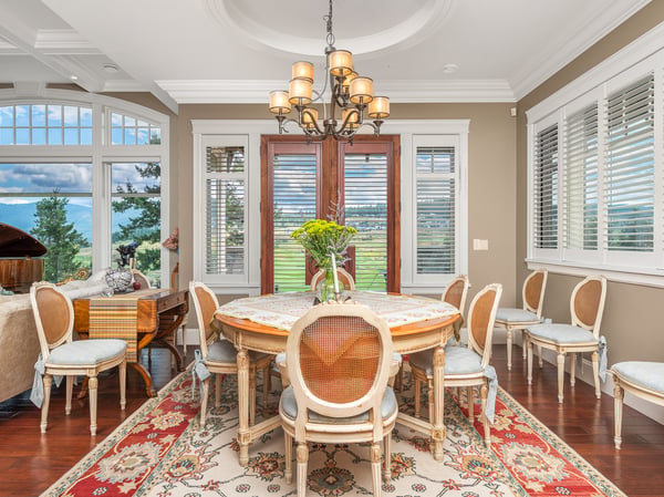 Bright dining room featuring large windows, tray ceilings, intricate details, and a spacious layout ideal for gatherings.