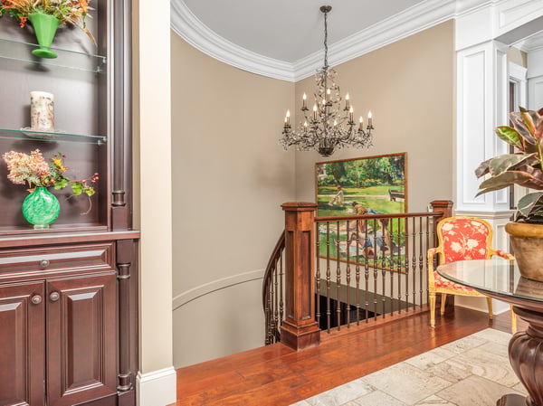 Welcoming foyer with a grand chandelier, showcasing fine craftsmanship and inviting views, drawing you into the living room.