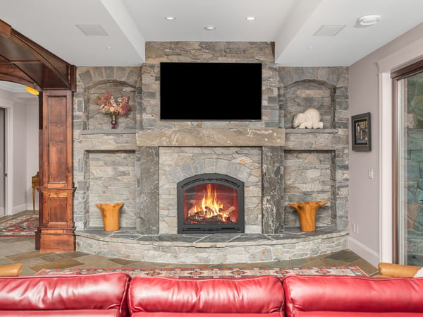 Captivating grand room featuring a massive stone fireplace, entertainment area, perfect for relaxation, gatherings, and sports broadcasting.