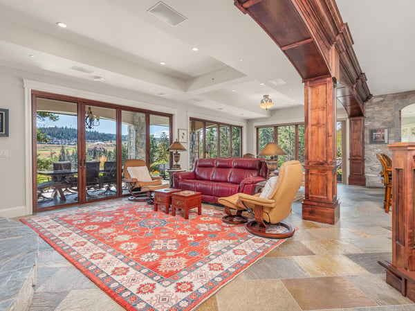 Spacious living area features large windows, natural light, and direct access to scenic outdoor views.