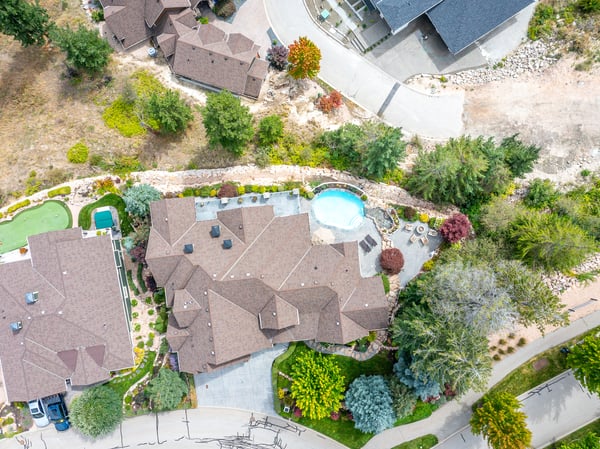 Stunning aerial view showcasing a beautifully landscaped property with a pool nestled in a tranquil neighborhood.