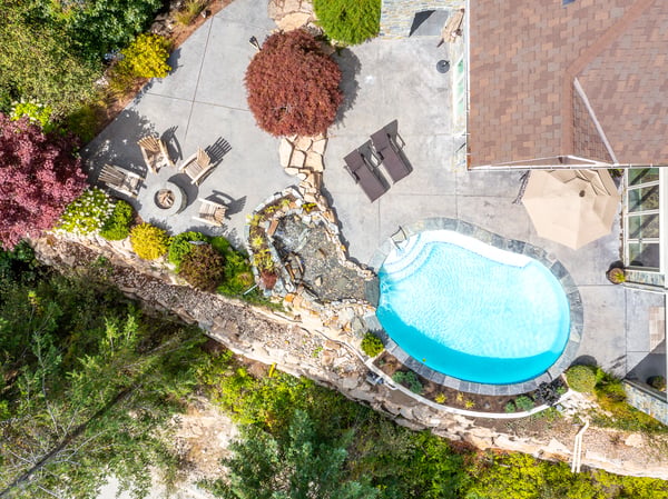 Discover a beautifully landscaped outdoor oasis featuring a pool, waterfall, and cozy seating areas.
