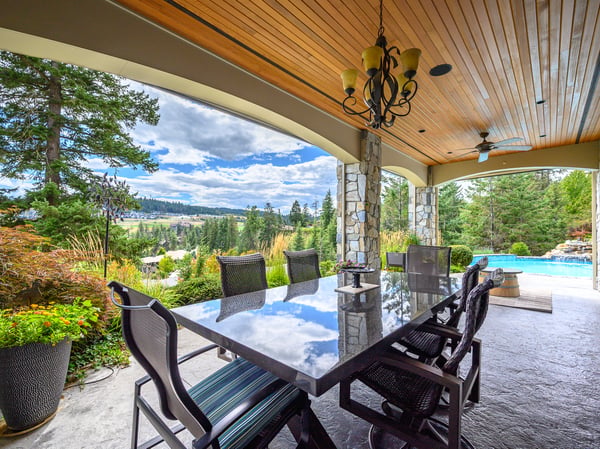 Spacious outdoor dining area with stunning views, perfect for entertaining amidst lush landscaping and a poolside retreat. Large thick granite table.