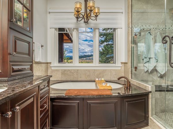This luxurious bathroom features a soaking tub, modern fixtures, and stunning outdoor views from the window.