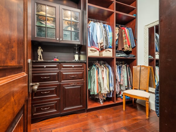 Discover a spacious walk-in closet featuring custom cabinetry and ample storage for all your wardrobe needs.