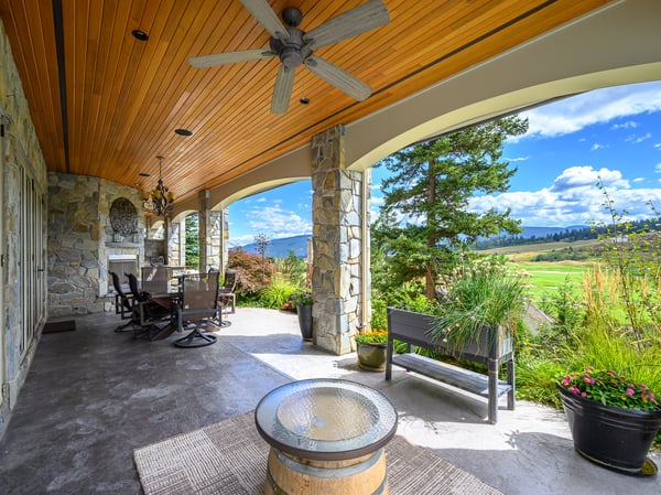 Spacious covered and screened patio features a stone fireplace, panoramic views, and ample seating for outdoor gatherings.