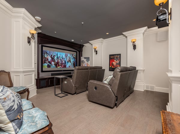 Experience cinematic enjoyment in this dedicated home theater, complete with plush seating and a large projector screen.
