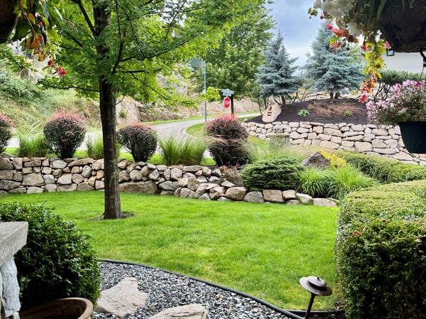Inviting outdoor space features landscaped gardens, mature trees, and a peaceful view of the surroundings.