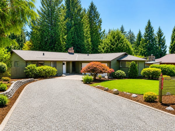 Spacious single-story home situated on a tranquil lot surrounded by lush greenery.