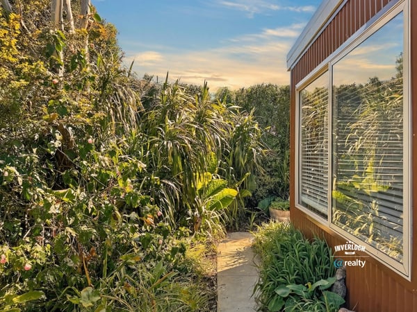 Discover a vibrant garden pathway leading to a bright and inviting home filled with natural light.