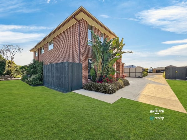 Spacious two-story home with ample outdoor space, lush landscaping, and convenient parking in a welcoming neighborhood.