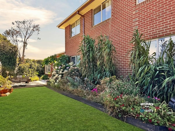 Well-maintained backyard surrounded by vibrant landscaping, perfect for outdoor gatherings or relaxing afternoons.
