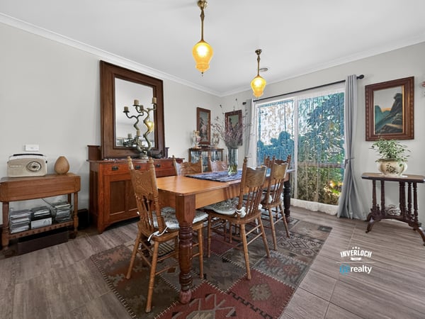 Discover a warm dining area featuring natural light, vintage decor, and inviting outdoor views.