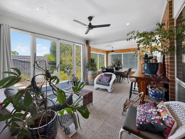 Bright and inviting sunroom with abundant greenery, perfect for relaxation and entertaining year-round.