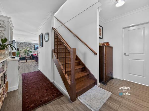 Spacious entryway with natural light, featuring a classic staircase and inviting living spaces beyond.