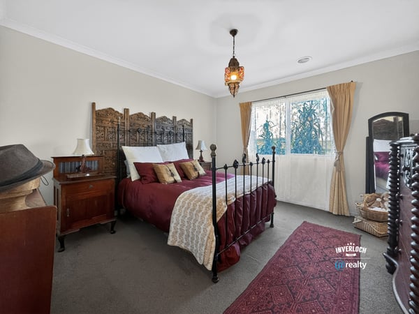 Cozy bedroom featuring unique decor, a wrought-iron bed frame, and ample natural light from the window.
