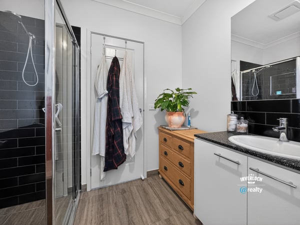 Modern bathroom featuring sleek finishes, a spacious shower, and ample storage for convenience and organization.