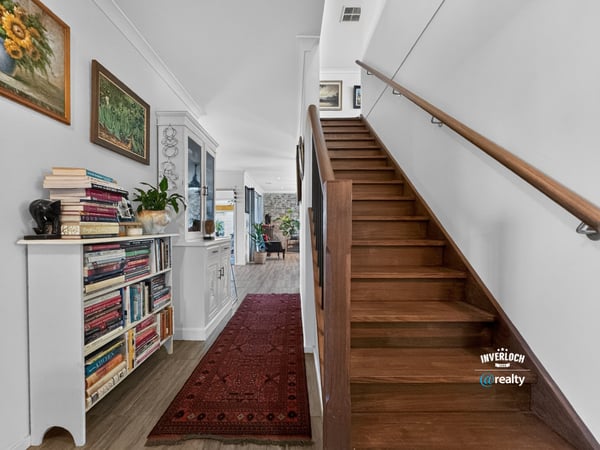 Spacious entryway featuring a wooden staircase, built-in shelving, and vibrant decor create a welcoming atmosphere.