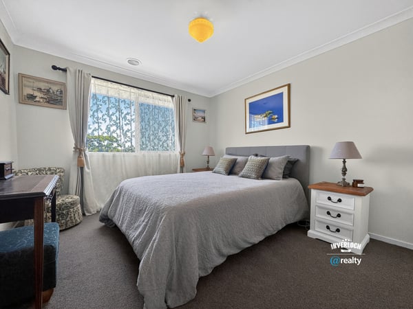 Spacious bedroom featuring natural light, cozy furnishings, and a tranquil atmosphere ideal for relaxation.