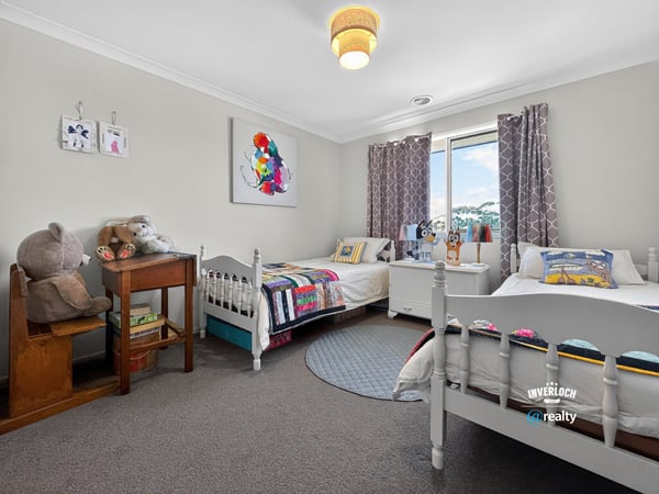Bright and inviting bedroom featuring cozy beds, playful decor, and ample natural light. Perfect for creativity!